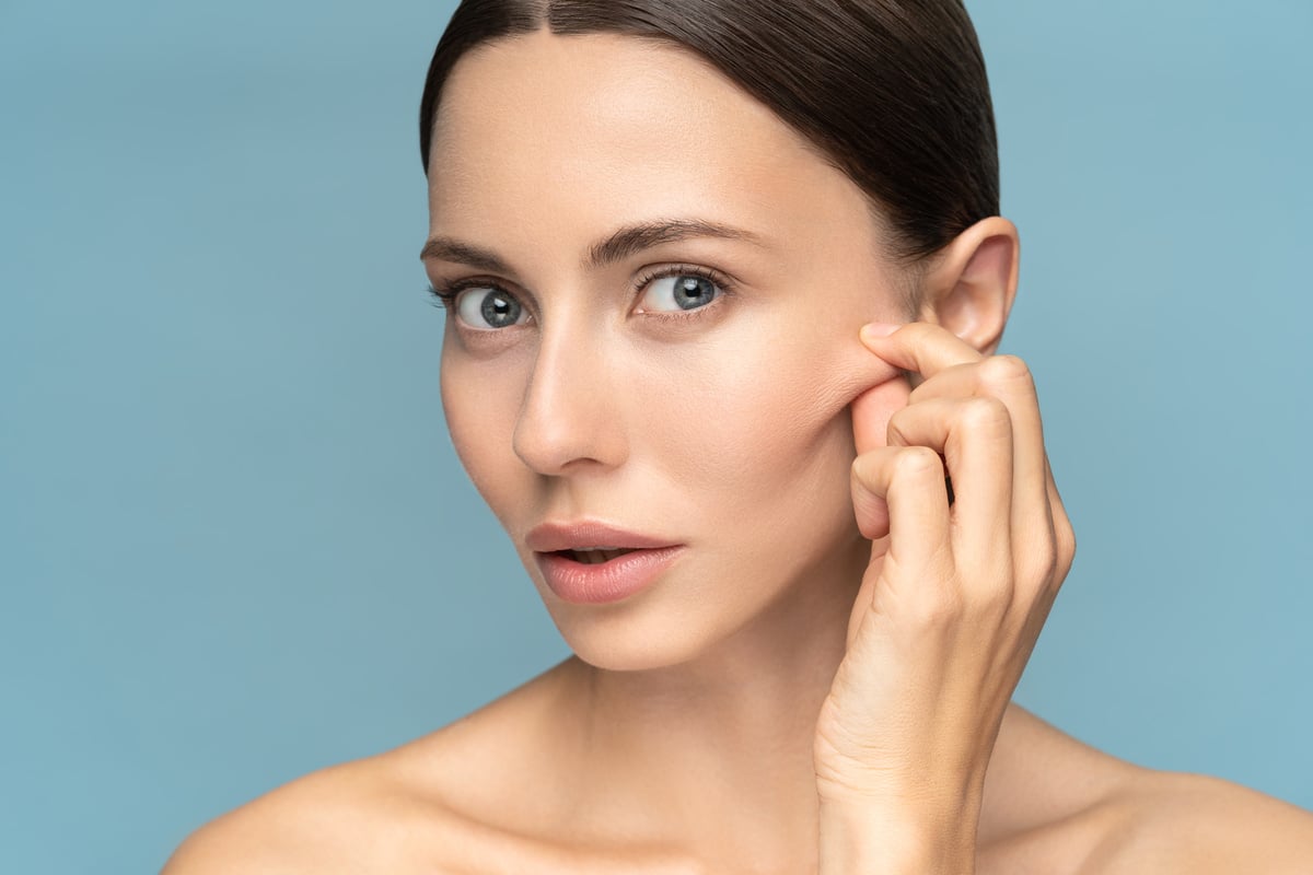 Woman without Makeup Touching Cheeks